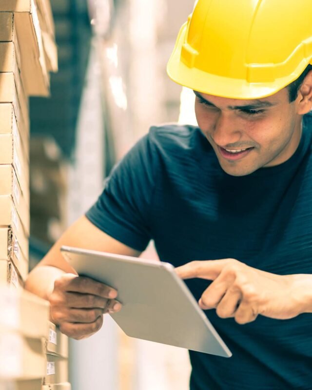 smart-indian-engineer-man-wearing-safety-helmet-doing-stock-tick-check-cardboard-stock-product-management-factory-warehouse-background (1)